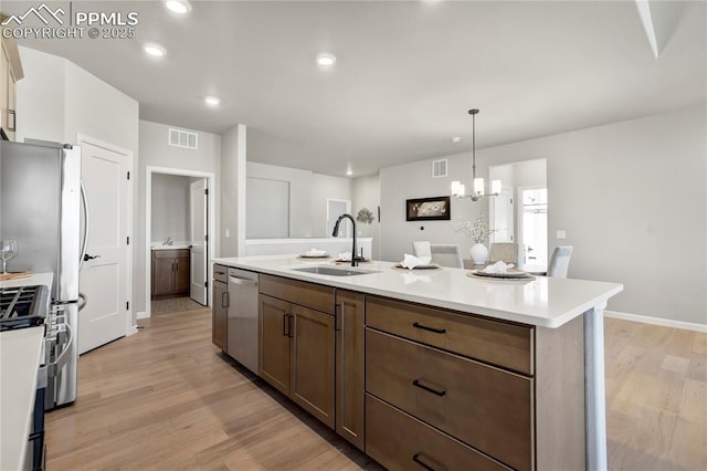 9484 Simper Hts, Colorado Springs, CO 80924 - kitchen featuring stainless steel appliances, a sink, light wood-type flooring, light countertops, and a chandelier
