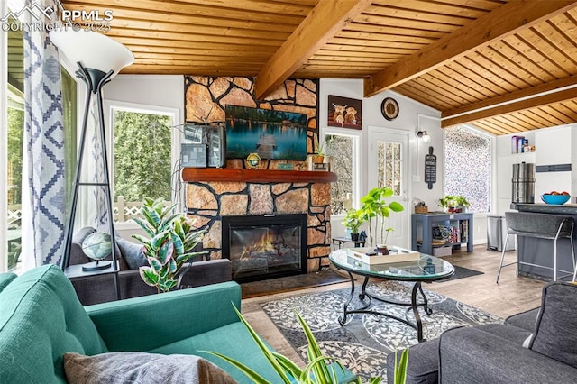 living area featuring lofted ceiling with beams, a wealth of natural light, and wooden ceiling