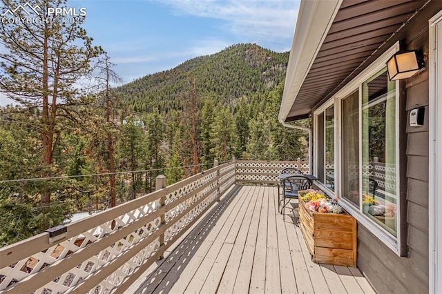 deck with a mountain view and a wooded view