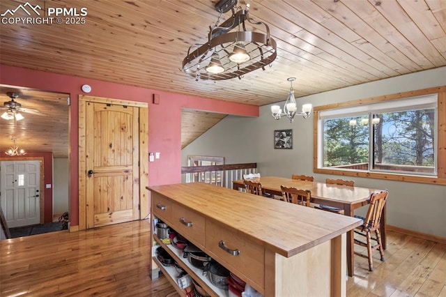 1200 Forest Edge Rd, Woodland Park, CO 80863 - dining room with wood ceiling, vaulted ceiling, ceiling fan with notable chandelier, baseboards, and light wood-type flooring