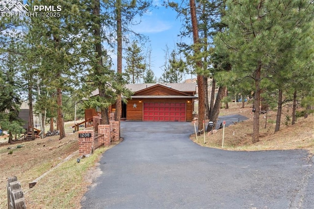 1200 Forest Edge Rd, Woodland Park, CO 80863 - rustic home featuring an attached garage and aphalt driveway