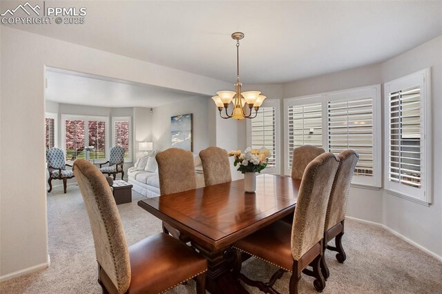 7820 Curlew Ct, Colorado Springs, CO 80920 - dining space with light colored carpet, baseboards, and a chandelier