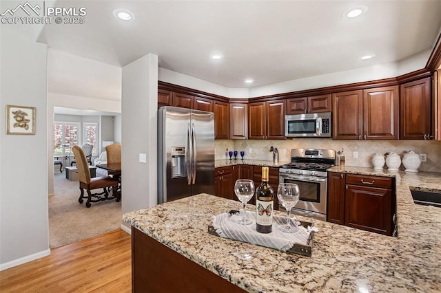 7820 Curlew Ct, Colorado Springs, CO 80920 - kitchen featuring light stone counters, tasteful backsplash, stainless steel appliances, and light wood-type flooring