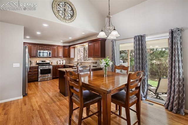 7820 Curlew Ct, Colorado Springs, CO 80920 - dining area with visible vents, high vaulted ceiling, light wood finished floors, a chandelier, and recessed lighting