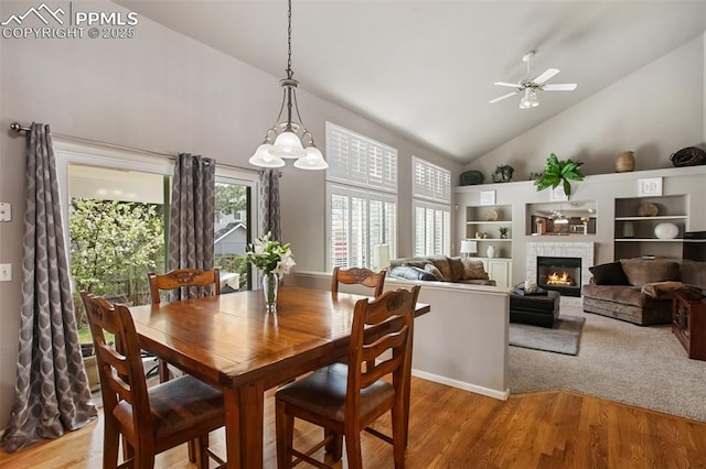7820 Curlew Ct, Colorado Springs, CO 80920 - dining room with a ceiling fan, high vaulted ceiling, wood finished floors, and a fireplace