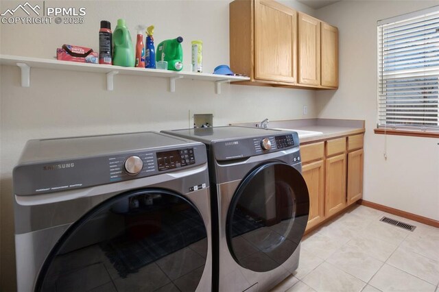 7820 Curlew Ct, Colorado Springs, CO 80920 - clothes washing area featuring visible vents, washing machine and dryer, a sink, cabinet space, and light tile patterned floors