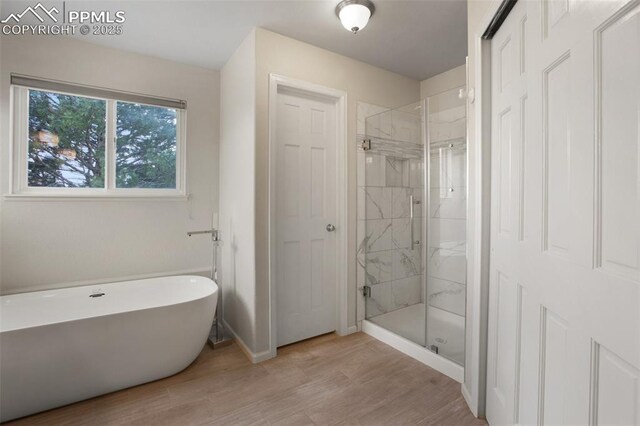 7820 Curlew Ct, Colorado Springs, CO 80920 - full bath with a freestanding bath, a marble finish shower, baseboards, and wood finished floors