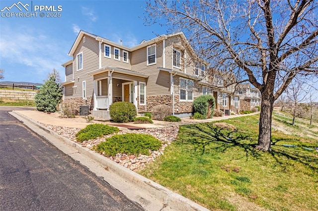 8081 Elk River Vw, Fountain, CO 80817 - view of front facade featuring fence, a front lawn, and stone siding