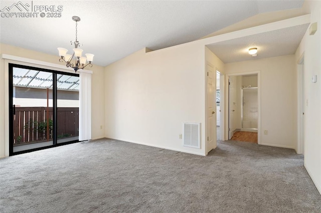 unfurnished room featuring a notable chandelier, visible vents, lofted ceiling, and carpet