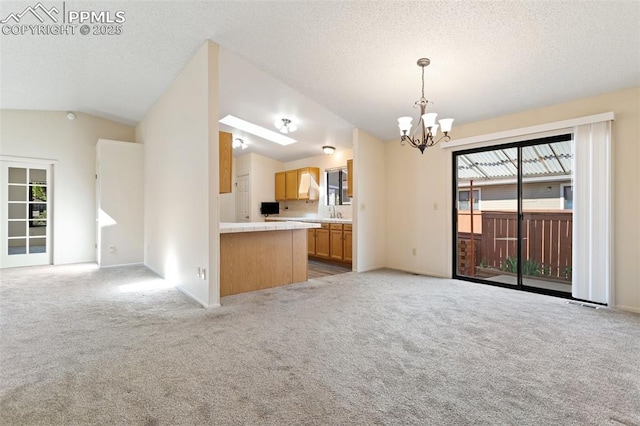 interior space featuring plenty of natural light, open floor plan, a notable chandelier, and light carpet