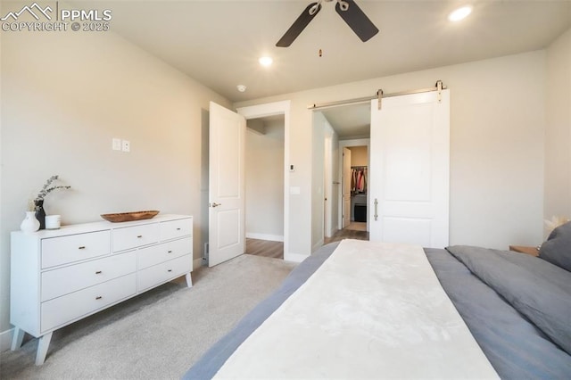 bedroom with ceiling fan, recessed lighting, a barn door, and light colored carpet