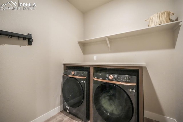 laundry area featuring baseboards, laundry area, light wood finished floors, and independent washer and dryer
