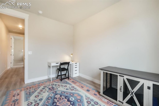 home office featuring baseboards and wood finished floors