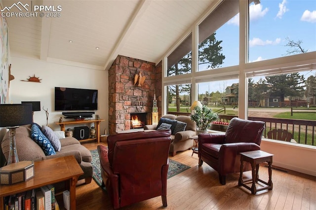 500 W Kellys Rd, Woodland Park, CO 80863 - living area with high vaulted ceiling, beam ceiling, wood-type flooring, plenty of natural light, and a stone fireplace