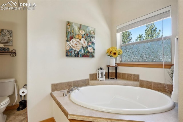full bathroom featuring baseboards, toilet, and a bath