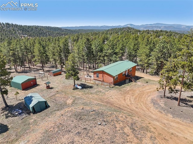 drone / aerial view featuring a wooded view and a mountain view