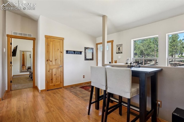 dining room featuring baseboards, light wood-type flooring, and visible vents