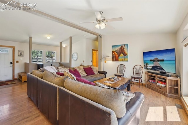 living room featuring a ceiling fan, lofted ceiling, and light wood finished floors