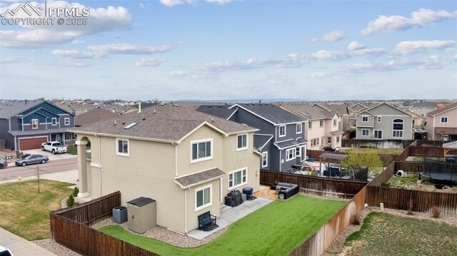 rear view of property featuring a residential view, stucco siding, a fenced backyard, a patio, and a yard