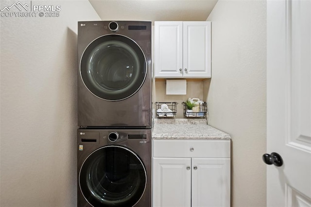 laundry area with cabinet space and stacked washing maching and dryer