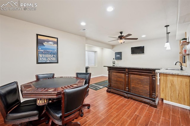office area with indoor wet bar, a ceiling fan, a sink, and wood finished floors