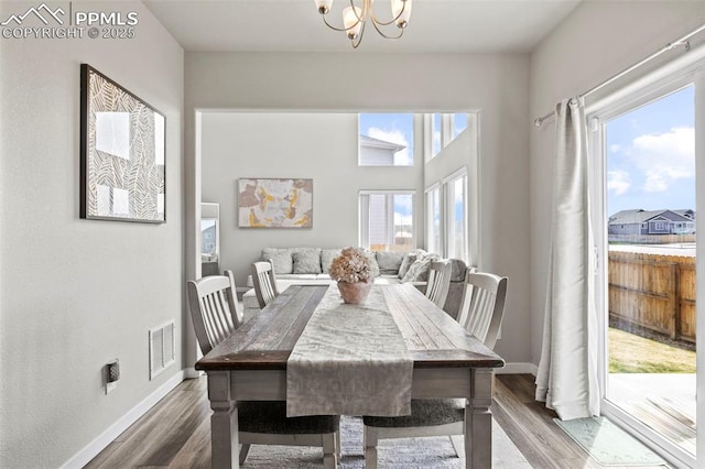 dining room featuring visible vents, baseboards, wood finished floors, and an inviting chandelier