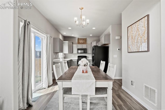 dining area with visible vents, wood finished floors, baseboards, recessed lighting, and a chandelier