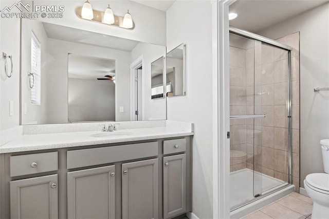 bathroom featuring vanity, tile patterned flooring, toilet, ceiling fan, and a shower stall