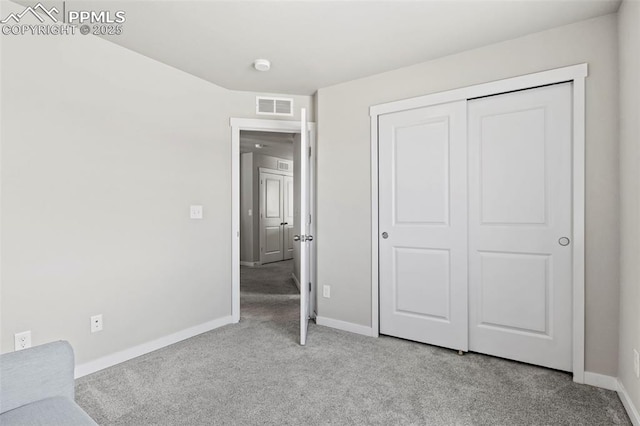 unfurnished bedroom featuring visible vents, carpet, baseboards, and a closet