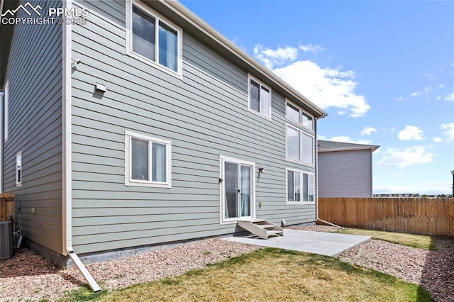 rear view of house featuring fence, a patio, and a yard