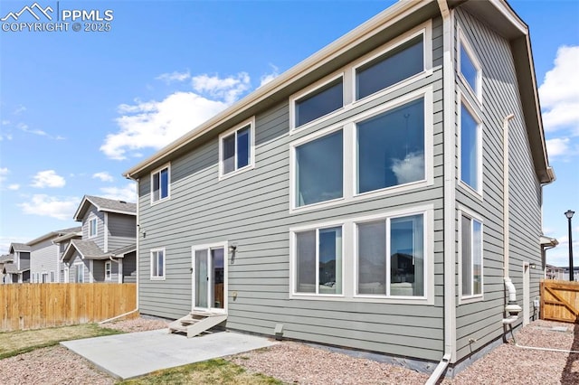 back of property featuring entry steps, fence private yard, and a patio area