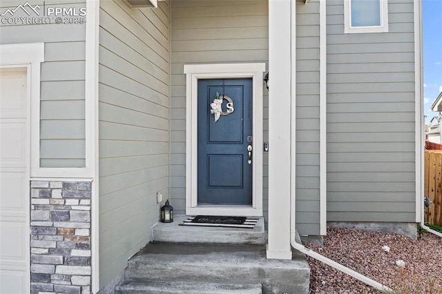 view of exterior entry featuring fence