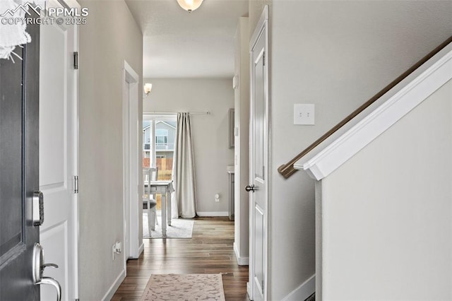 entryway featuring baseboards and dark wood-style floors