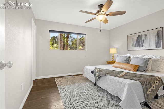 bedroom featuring a ceiling fan, baseboards, visible vents, and wood finished floors