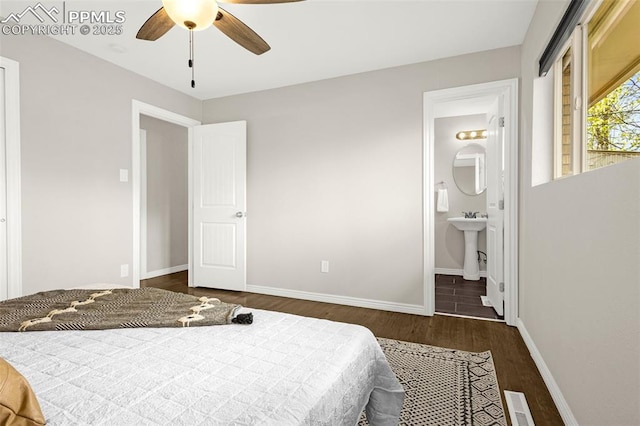 bedroom featuring a sink, ensuite bath, a ceiling fan, baseboards, and wood finished floors