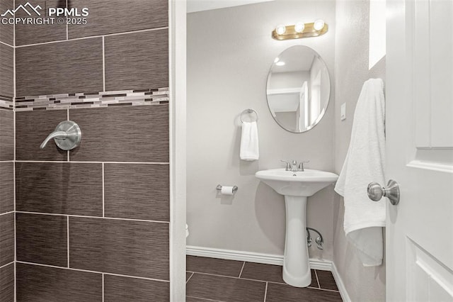 full bathroom featuring baseboards, tile patterned floors, and tiled shower
