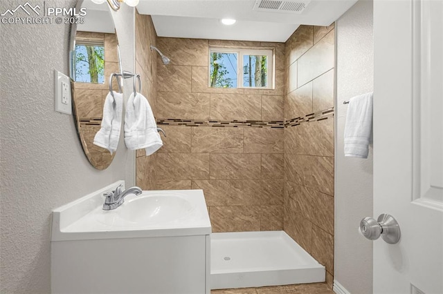bathroom with visible vents, a healthy amount of sunlight, and a stall shower