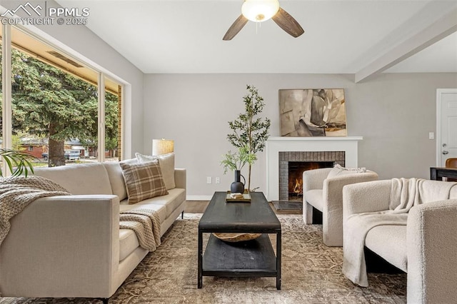 living room featuring a ceiling fan, a brick fireplace, and wood finished floors