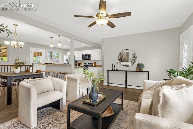 living area featuring recessed lighting, wood finished floors, and ceiling fan with notable chandelier