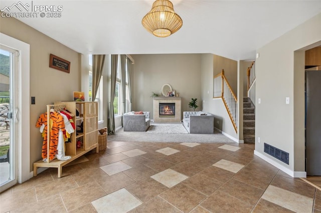 133 Wheat Ridge St, Palmer Lake, CO 80133 - entrance foyer with a glass covered fireplace and stairs