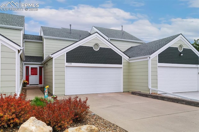 multi unit property featuring an attached garage, roof with shingles, and driveway