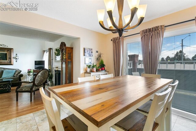 dining area with light tile patterned floors and a notable chandelier