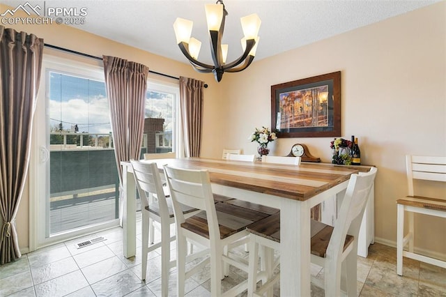 dining space featuring visible vents, baseboards, and a notable chandelier