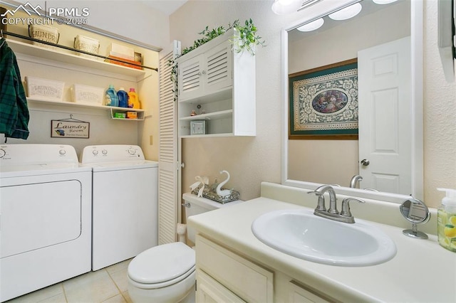 bathroom featuring vanity, tile patterned flooring, washing machine and dryer, and toilet