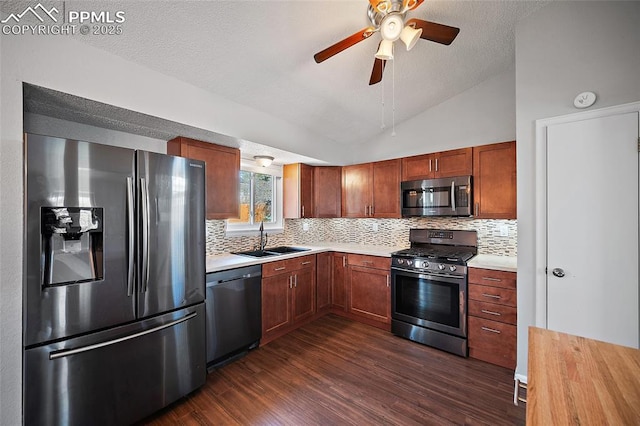 kitchen with appliances with stainless steel finishes, tasteful backsplash, a sink, light countertops, and dark wood-type flooring