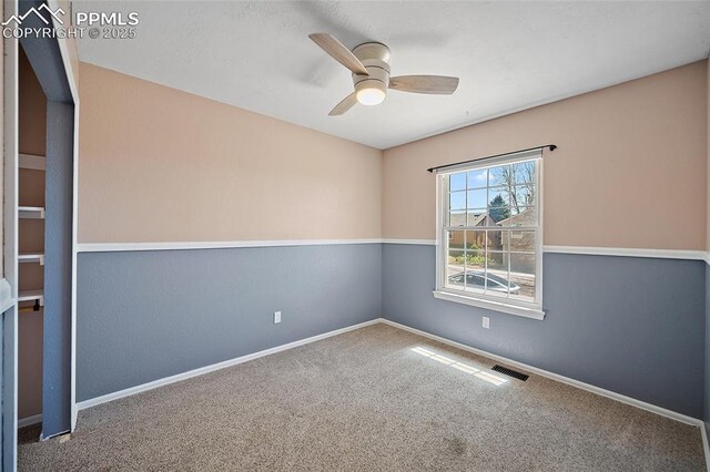 carpeted spare room with a ceiling fan, baseboards, and visible vents