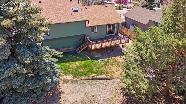 rear view of house with a wooden deck, fence, a yard, a shingled roof, and stairs