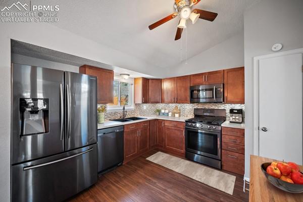 kitchen with light countertops, stainless steel appliances, a sink, and tasteful backsplash