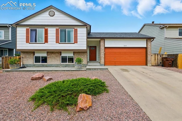 2032 Woodsong Way, Fountain, CO 80817 - split level home featuring brick siding, an attached garage, and driveway