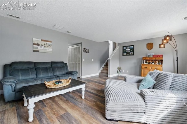 2032 Woodsong Way, Fountain, CO 80817 - living area with a textured ceiling, wood finished floors, stairs, and baseboards